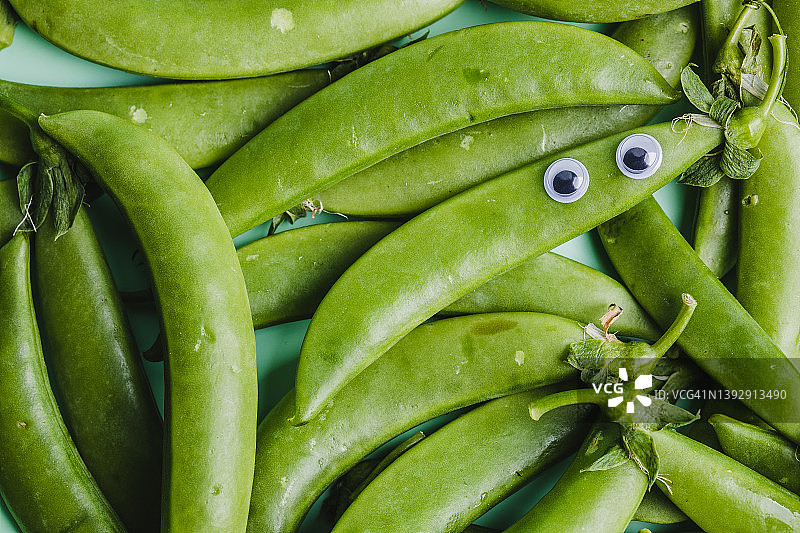 全帧镜头的绿色豌豆与googly的眼睛图片素材