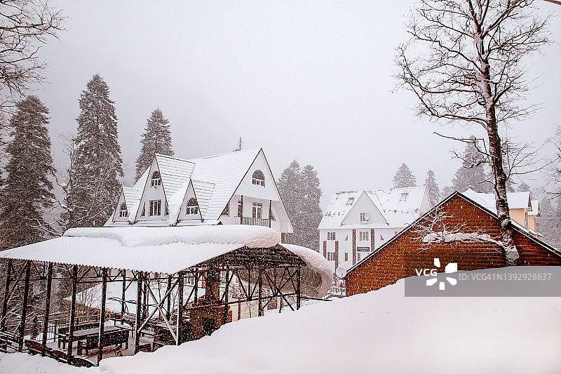 在一个下雪的冬天，一个小山村的小村舍图片素材