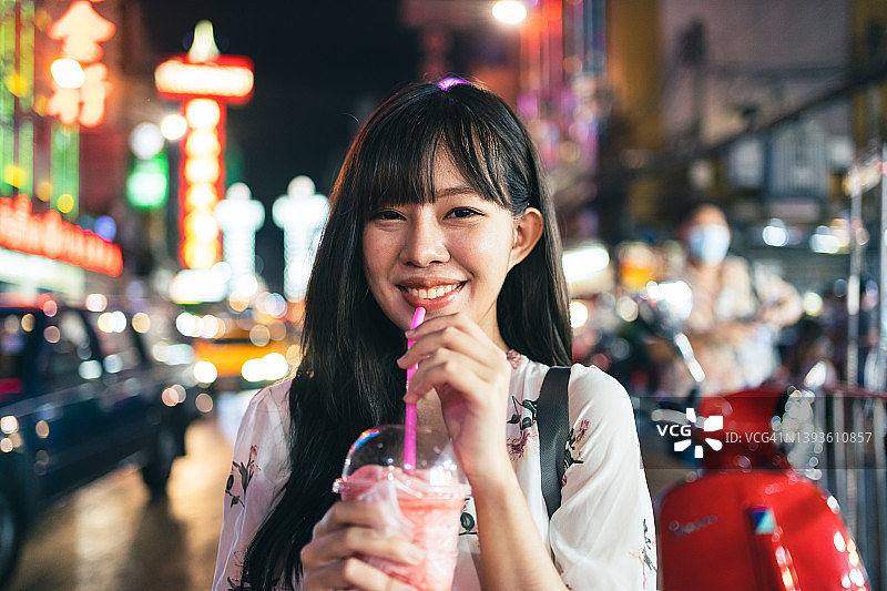年轻的亚洲女子享受各种街头食品在曼谷唐人街的曼谷，泰国曼谷。图片素材