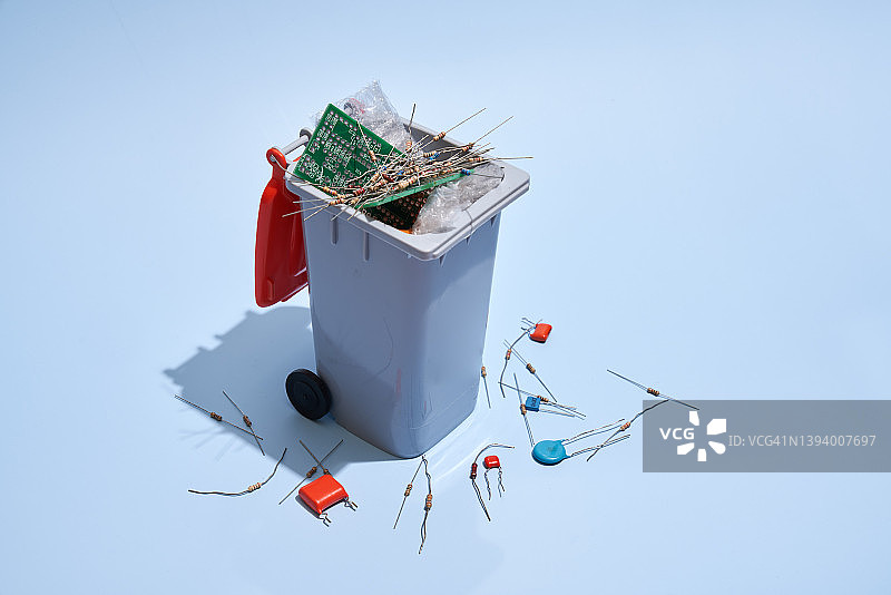 蓝色背景的废物容器内的电子垃圾图片素材