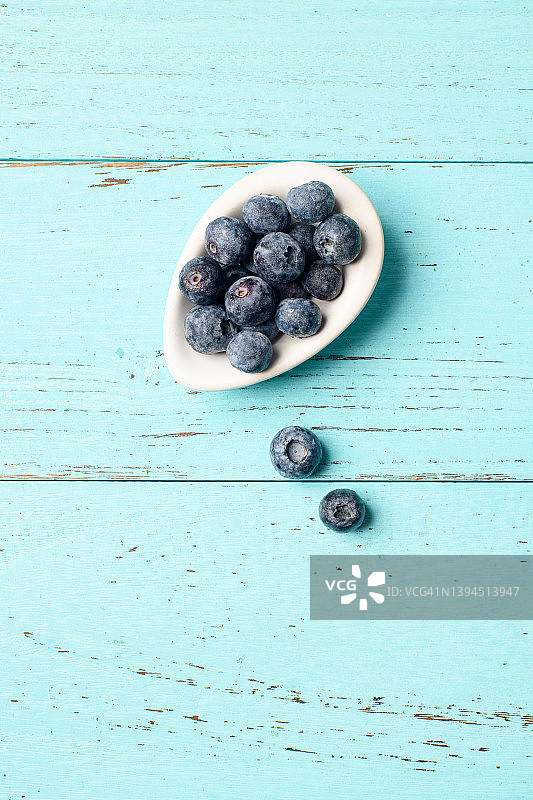 静物与蓝莓碗在绿松石色的桌子图片素材