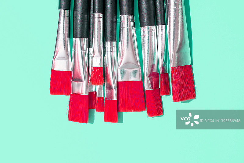 绿色背景上的一些红色画笔。创造力的概念。图片素材