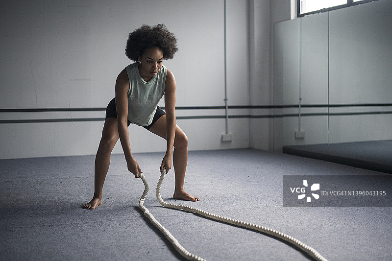 非洲裔美国妇女在用战绳锻炼后看起来很疲惫图片素材