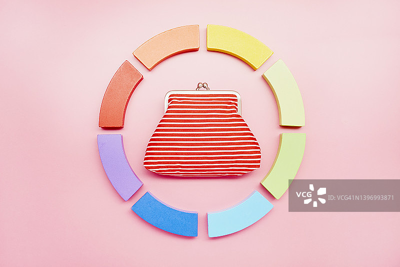 饼图由彩色的积木和钱包在粉红色的背景图片素材