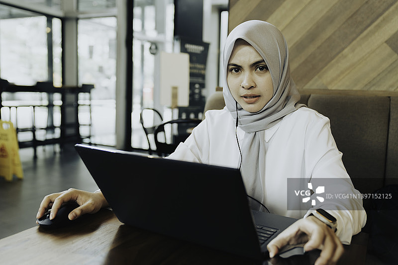 肖像亚洲穆斯林妇女在咖啡馆工作图片素材