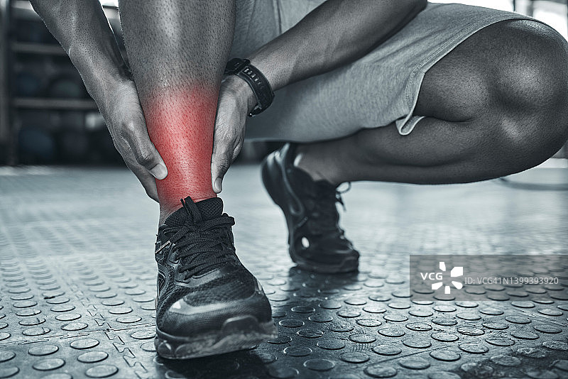 脚踝疼痛会阻碍运动。使用cgi来识别身体的肌肉疼痛。特写训练师在疼痛中触摸他们的腿。运动员用手触摸酸痛的腿。注意脚踝扭伤图片素材