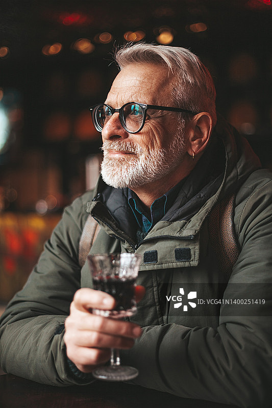 快乐的老男人在酒吧喝酒，在酒吧喝酒放松。图片素材