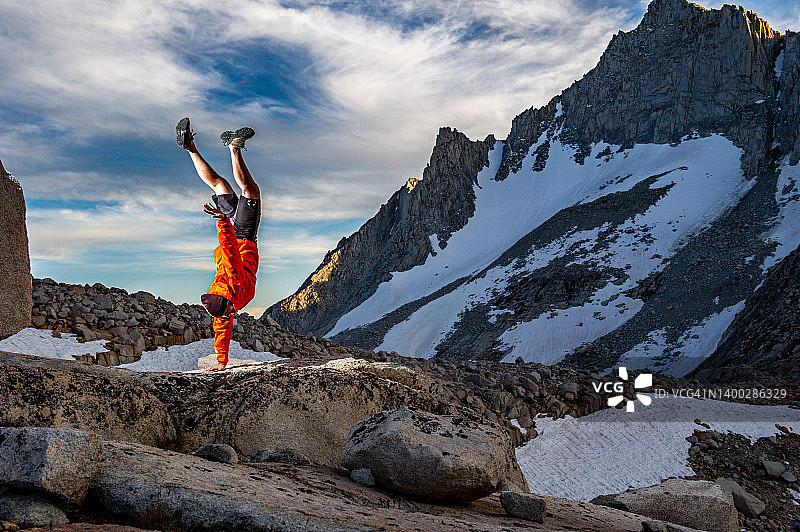 在雪山顶上庆祝成功的越野跑者图片素材