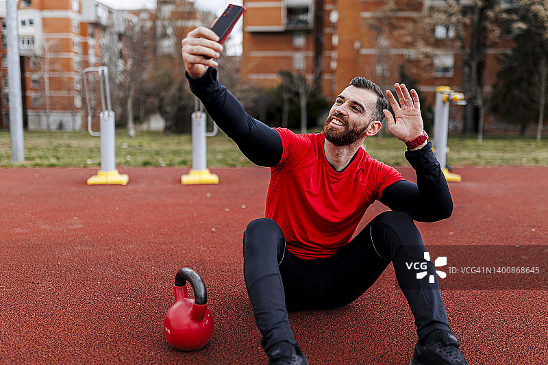 运动男在户外运动训练时进行视频通话图片素材