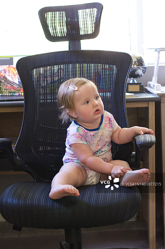 女婴坐在办公椅上图片素材