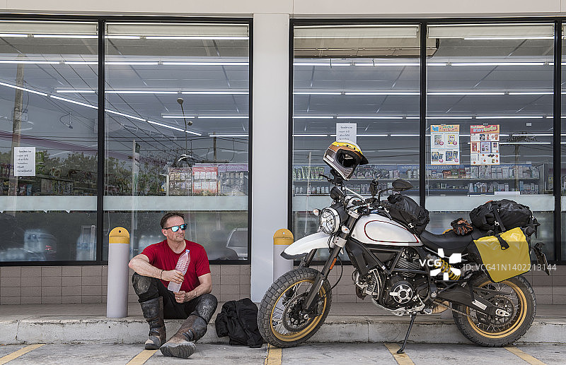 一名男子在泰国骑摩托车休息图片素材