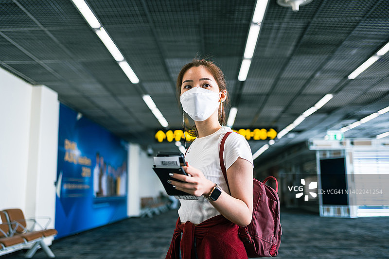 在机场候机厅使用智能手机的亚洲年轻女性图片素材