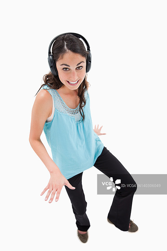 一个快乐的女人一边听音乐一边跳舞的肖像图片素材