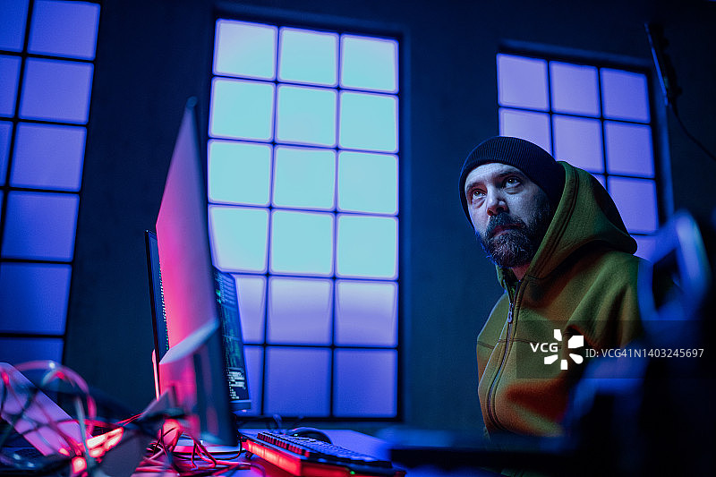 黑客在暗室里操作电脑，低角度视角。图片素材
