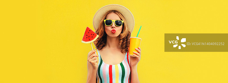 夏天五颜六色的肖像美丽的年轻女子吹她的嘴唇与一杯果汁和棒棒糖或冰淇淋形状的西瓜片戴着黄色的背景，空白的拷贝空间图片素材