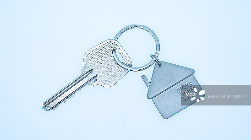 钥匙链与房子符号和钥匙在蓝色背景，房地产概念图片素材