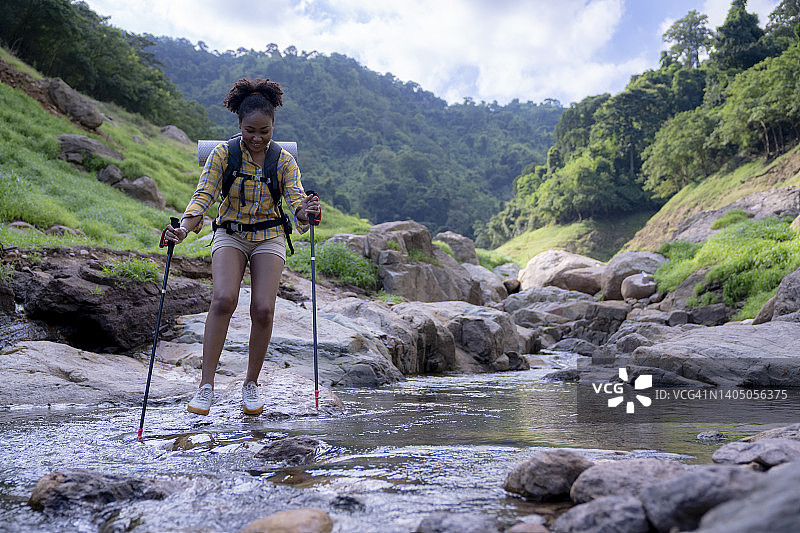 快乐的女性徒步旅行与登山杆在大自然中旅行图片素材