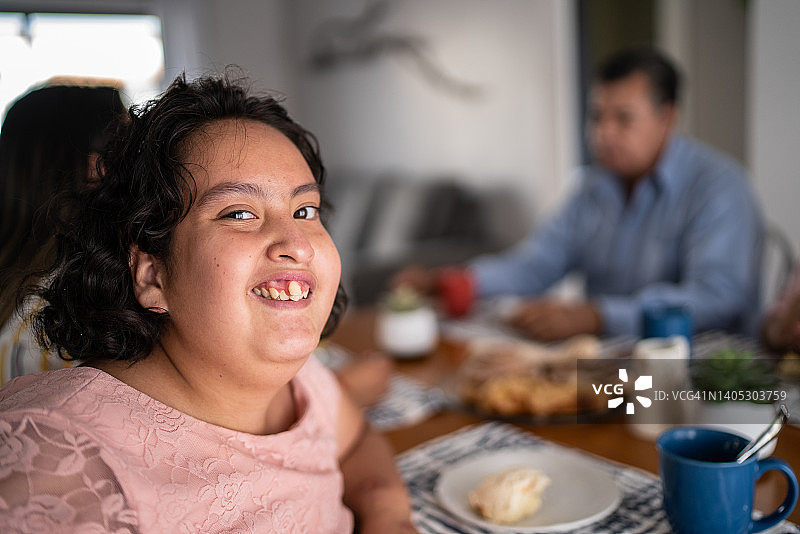 精神运动障碍女孩和家人在家里吃早餐的画像图片素材
