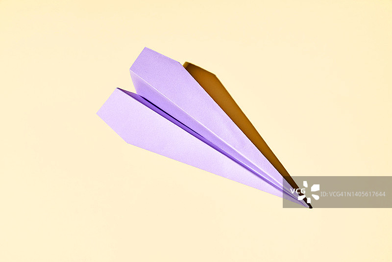 黄色背景上的紫色纸飞机图片素材