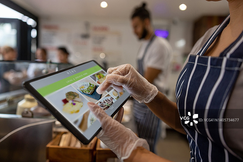 女服务员在餐厅用平板电脑点菜的特写图片素材
