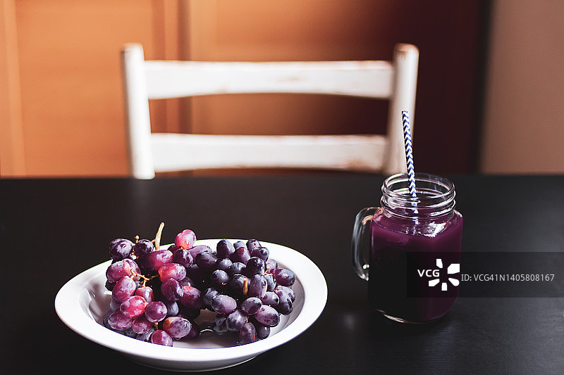 厨房桌上有新鲜的葡萄和果汁。图片素材