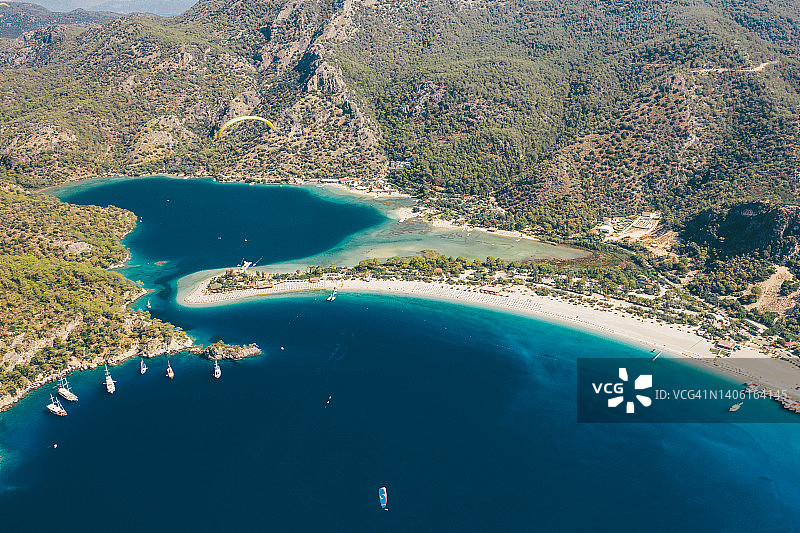 蓝色泻湖鸟瞰图，碧蓝的大海，白色的沙滩，带着遮阳伞和游船。Oludeniz Mugla,土耳其。图片素材