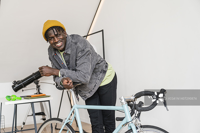 微笑的男人倚在家里的自行车上图片素材