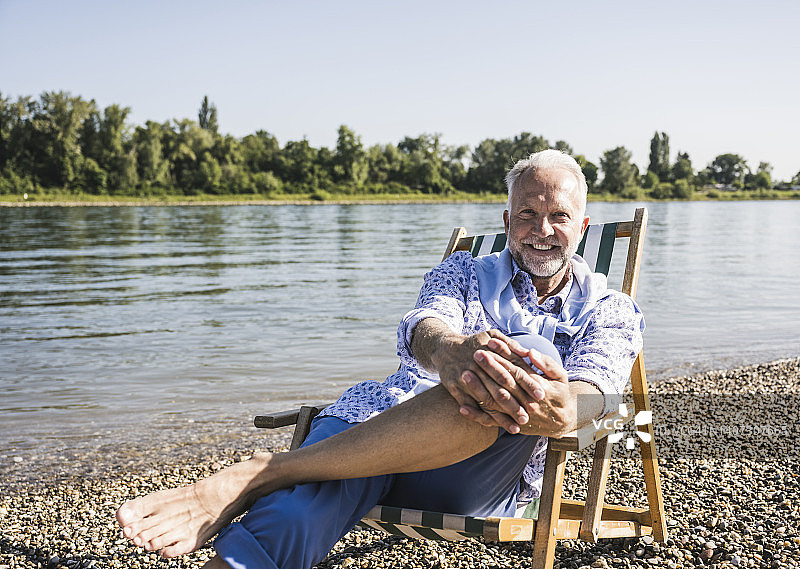 阳光灿烂的日子，微笑的老人在河岸图片素材