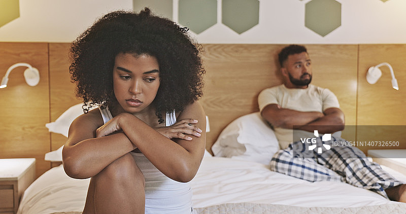 不快乐的男性和女性有关系问题，并即将分手。一对非裔美国夫妇早上坐在卧室里互相发火。一对心烦意乱的年轻夫妇互相躲避图片素材