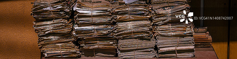 旧报纸堆准备回收，环保，可重复使用的材料概念，泛黄，棕色和脆纸。横幅图片素材
