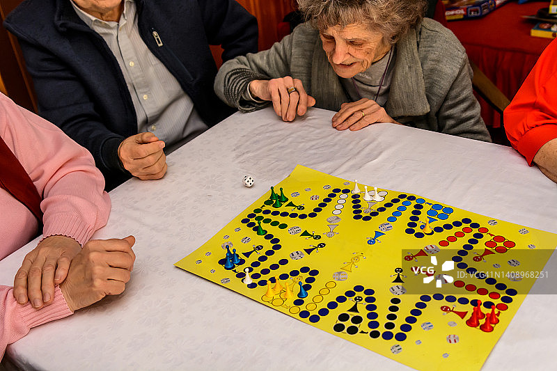 一小群老年人在玩ludo游戏。图片素材