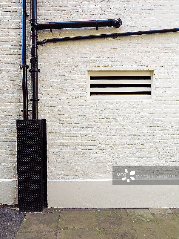 英国伦敦，白色砖墙，黑色金属管和人行道图片素材