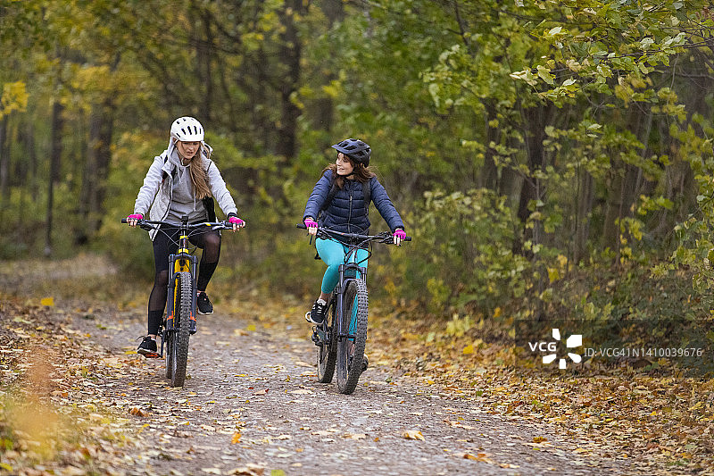 两个年轻女人骑着电动自行车图片素材