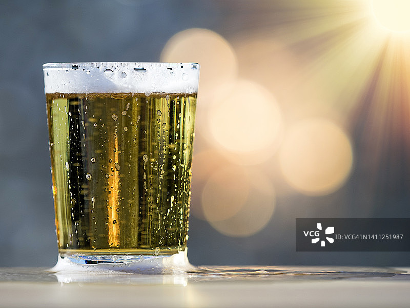 一品脱冰啤酒，盛在阳光照耀下的玻璃杯里。图片素材