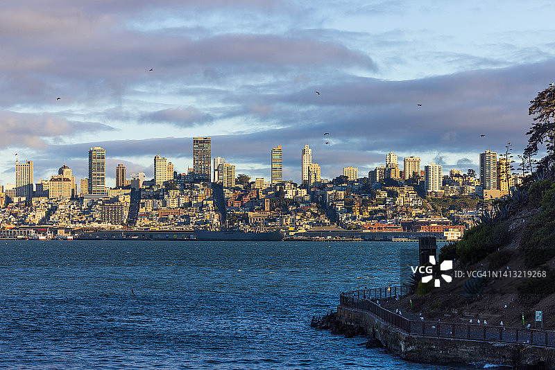 从海上俯瞰旧金山市中心天际线的日落美景图片素材