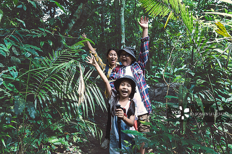 快乐的亚洲家庭徒步旅行，探索和了解自然图片素材