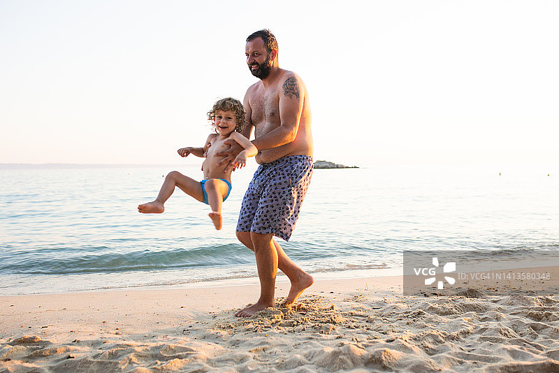 父亲和儿子在海滩上玩得很开心图片素材