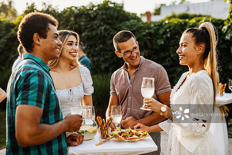 一群多种族的人在夏天享受游园会，边喝边聊边吃零食图片素材