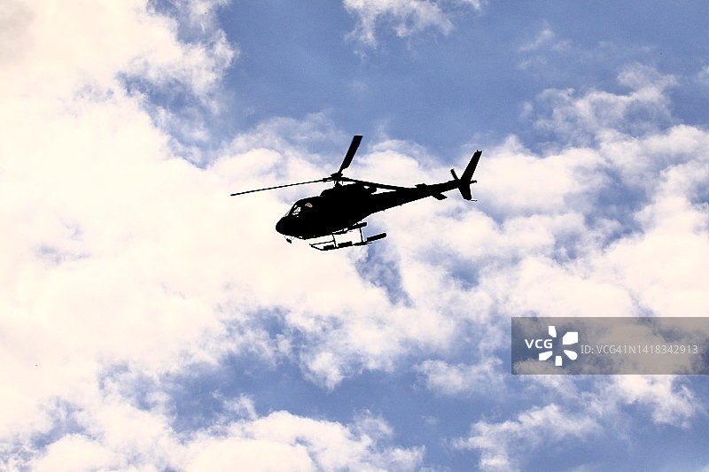 空中监控中救援直升机的剪影图片素材