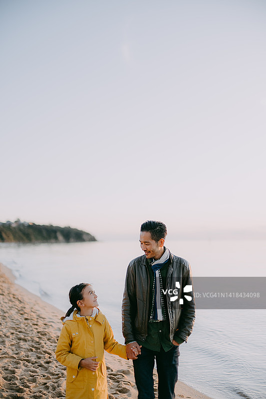 澳大利亚，父亲和女儿在冬天的海滩上散步图片素材