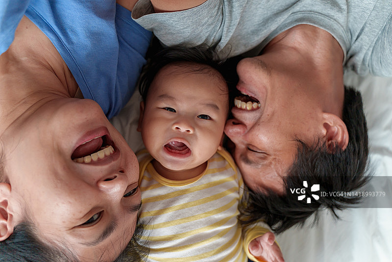 幸福的亚洲家庭在床上一起自拍图片素材