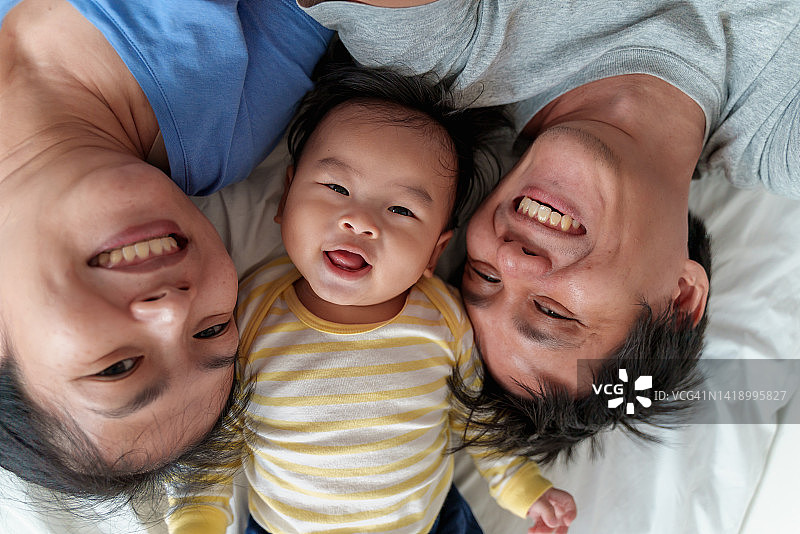 幸福的亚洲家庭在床上一起自拍图片素材
