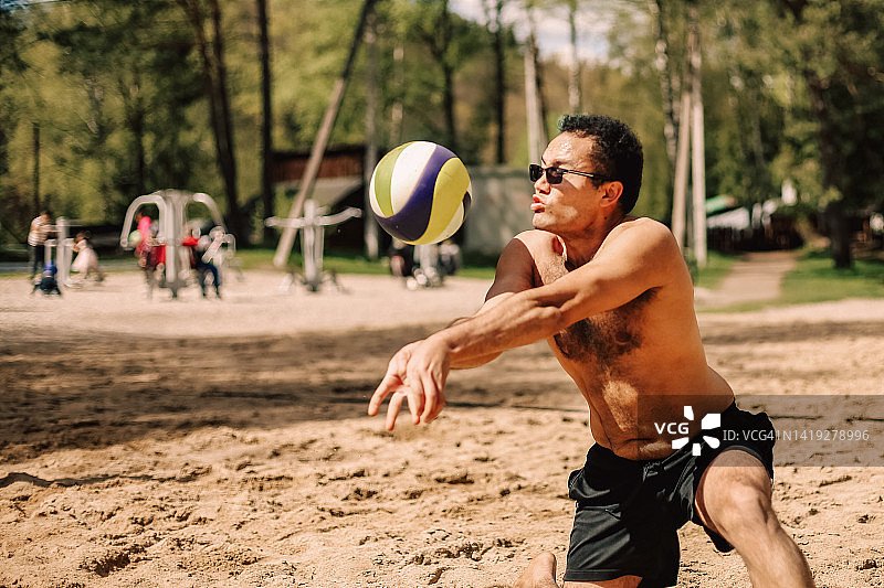 户外打沙滩排球的男性肖像。生活方式运动摄影与人。多种族的人带着墨镜打球。图片素材
