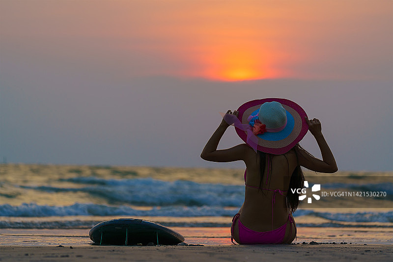 在温暖阳光明媚的夏天，冲浪女孩们拿着冲浪板站在海边。图片素材