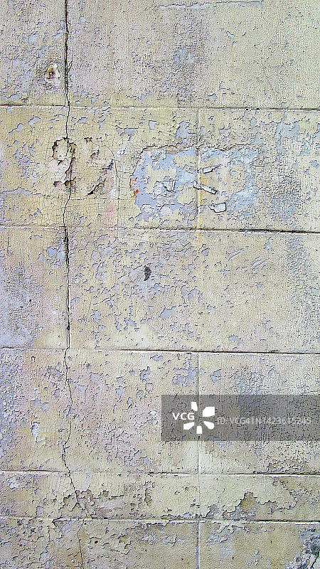 比利时布鲁塞尔，一堵有裂缝的煤渣砖墙上一层层风化剥落的蓝色和灰色油漆图片素材