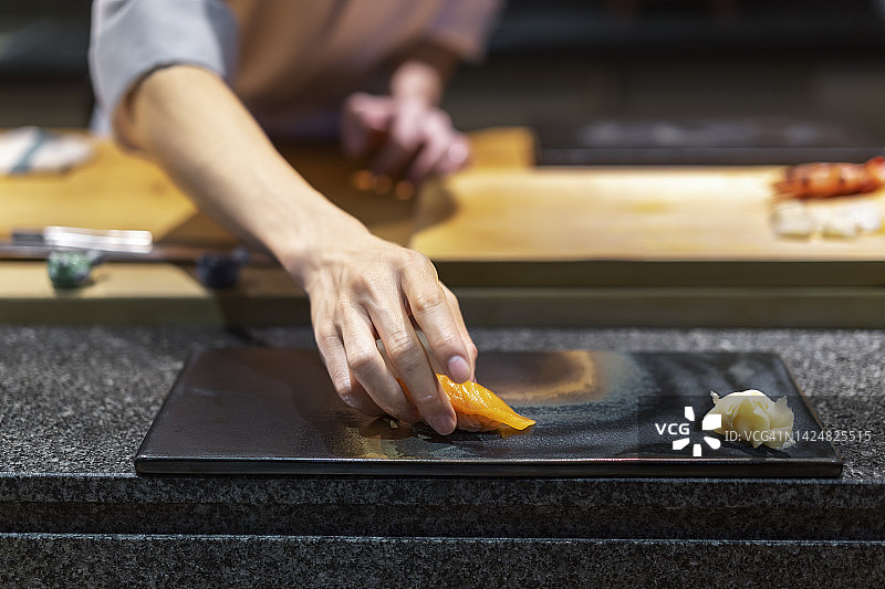 厨师把寿司放在盘子里的特写镜头图片素材