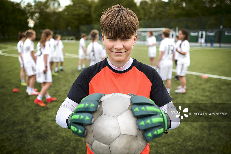 一个十几岁的女孩足球队的守门员肖像在运动场上图片素材