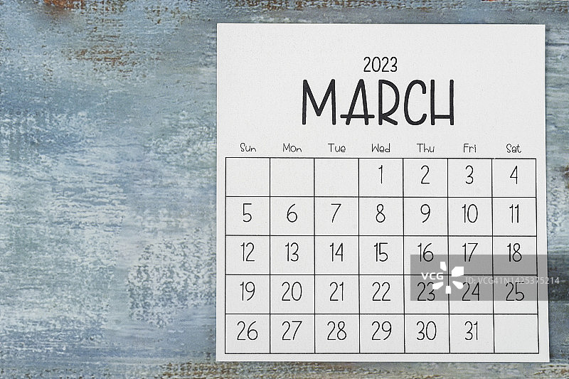 2023日历台:手工制作用于家庭办公室。3月是组织者用木桌背景计划和截止日期的月份。图片素材