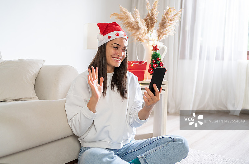 微笑的女人用视频电话庆祝圣诞节图片素材