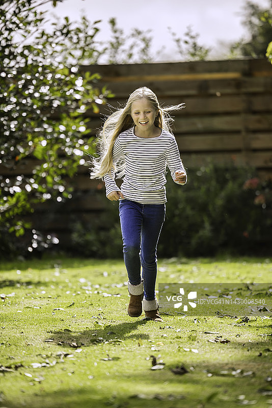 八岁的小女孩在花园里跑步图片素材